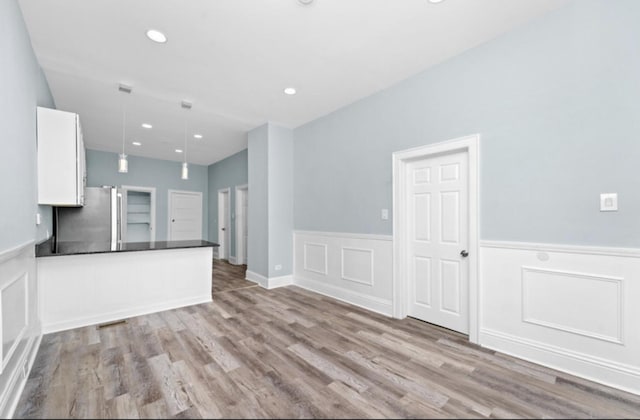 4329 S Wood St, Chicago, IL 60609 - unfurnished living room with wood finished floors, wainscoting, recessed lighting, and a decorative wall