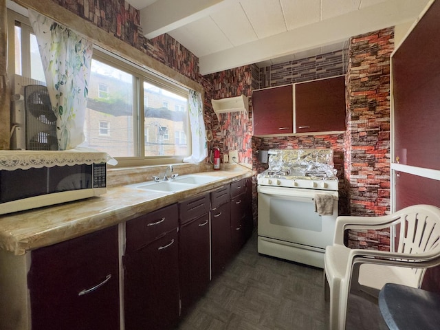 1912 W Hood Ave Unit 1B, Chicago, IL 60660 - kitchen featuring white range with gas stovetop, beamed ceiling, healthy amount of natural light, light countertops, and dark brown cabinets