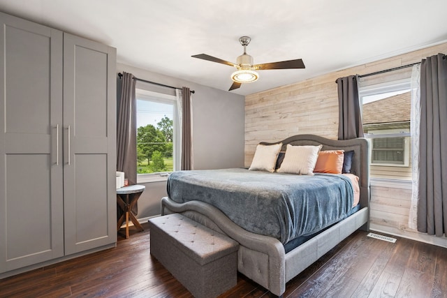 492 Winthrop Ave, Glendale Heights, IL 60139 - bedroom featuring multiple windows, wooden walls, dark wood finished floors, and a ceiling fan