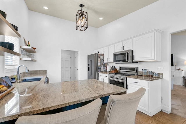 4006 Tallgrass Dr, Champaign, IL 61822 - kitchen with stainless steel appliances, open shelves, light stone counters, a peninsula, and white cabinets