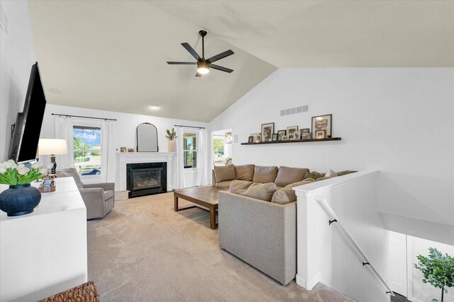 4006 Tallgrass Dr, Champaign, IL 61822 - living area with light carpet, vaulted ceiling, a ceiling fan, and a fireplace with flush hearth