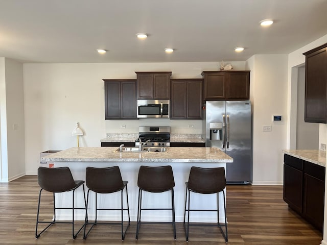 1137 Crestview Ln, Pingree Grove, IL 60140 - kitchen with appliances with stainless steel finishes, dark brown cabinetry, dark wood-style floors, a center island with sink, and recessed lighting