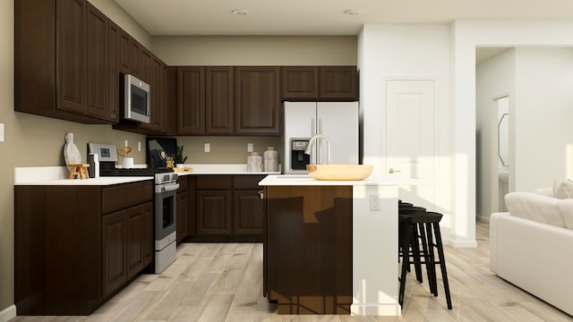 12058 Jordi Rd, Huntley, IL 60142 - kitchen featuring gas range oven, white refrigerator with ice dispenser, stainless steel microwave, light countertops, and a center island with sink