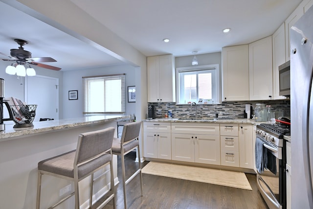 6869 N Overhill Ave Unit 2B, Chicago, IL 60631 - kitchen with stainless steel appliances, dark wood-style flooring, tasteful backsplash, white cabinets, and light stone counters