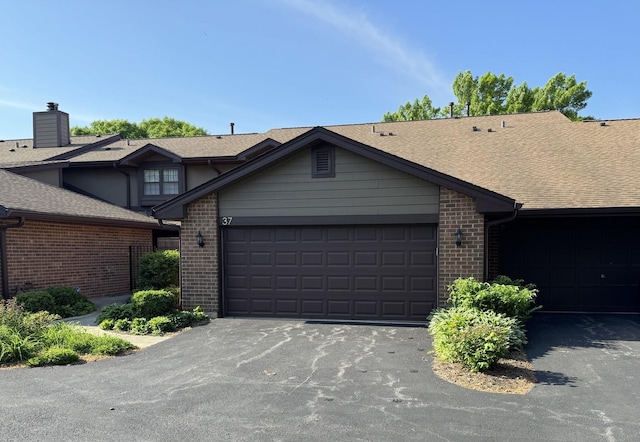 37 White Birch Ln, Westmont, IL 60559 - view of front of home featuring brick siding, asphalt driveway, a shingled roof, a garage, and a chimney