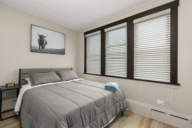 5901 N Navarre Ave, Chicago, IL 60631 - bedroom with multiple windows, wood finished floors, baseboard heating, and a decorative wall