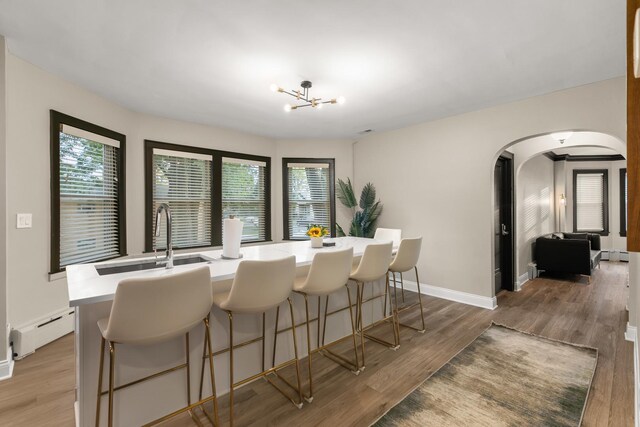 5901 N Navarre Ave, Chicago, IL 60631 - dining area featuring baseboard heating, arched walkways, light wood-type flooring, and a chandelier