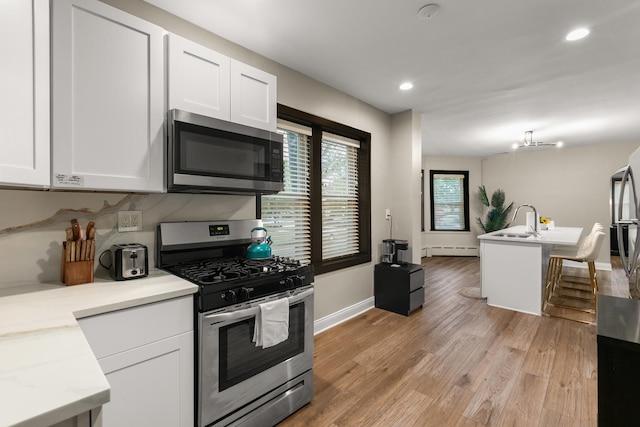 5901 N Navarre Ave, Chicago, IL 60631 - kitchen with appliances with stainless steel finishes, baseboard heating, white cabinets, light wood finished floors, and recessed lighting