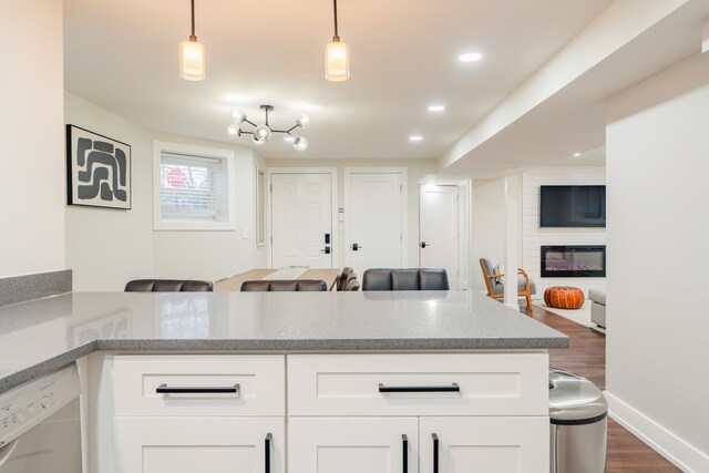 5901 N Navarre Ave, Chicago, IL 60631 - kitchen featuring dishwasher, open floor plan, dark wood-style floors, a large fireplace, and white cabinetry