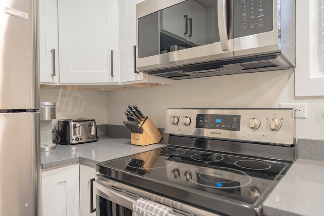 5901 N Navarre Ave, Chicago, IL 60631 - kitchen with appliances with stainless steel finishes, white cabinets, and light stone counters