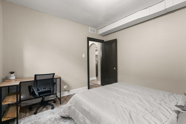 5901 N Navarre Ave, Chicago, IL 60631 - bedroom featuring arched walkways, wood finished floors, and a desk