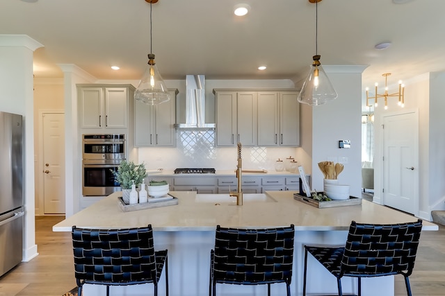 16642 S Sun Meadow Dr, Lockport, IL 60441 - kitchen with wall chimney range hood, stainless steel appliances, a kitchen bar, tasteful backsplash, and light wood-style floors