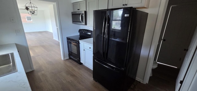 5406 N Arrow Dr, Peoria, IL 61614 - kitchen featuring black appliances, dark wood-style floors, decorative light fixtures, and tasteful backsplash