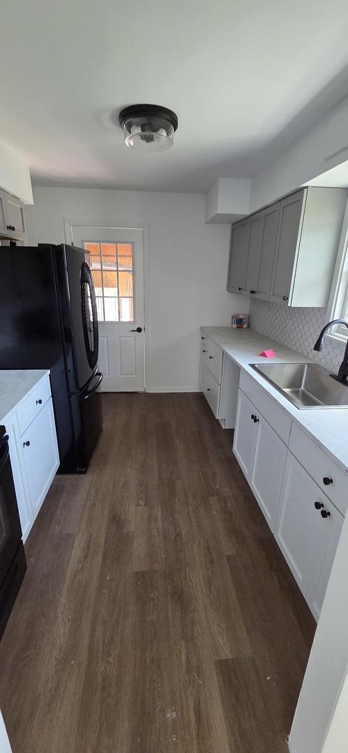 5406 N Arrow Dr, Peoria, IL 61614 - kitchen featuring freestanding refrigerator, dark wood finished floors, light countertops, backsplash, and range with electric stovetop