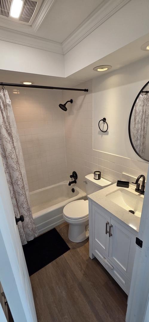 5406 N Arrow Dr, Peoria, IL 61614 - bathroom with crown molding, vanity, wood finished floors, shower / bath combo, and decorative backsplash