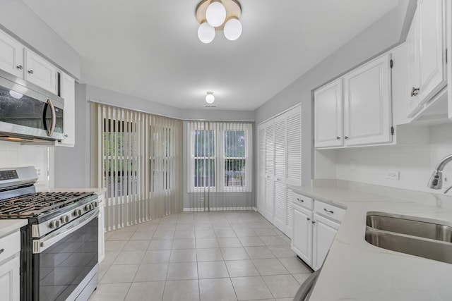 13 Willow Pkwy, Buffalo Grove, IL 60089 - kitchen featuring stainless steel appliances, white cabinets, tasteful backsplash, and light tile patterned floors