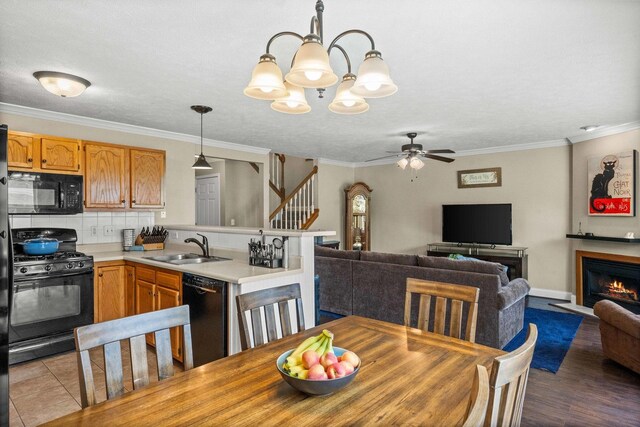 1201 Riviera Dr, Bloomington, IL 61701 - dining space featuring a chandelier, stairway, a ceiling fan, ornamental molding, and a lit fireplace
