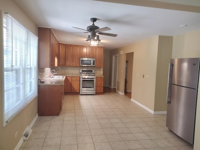 1544 Towhee Ln, Naperville, IL 60565 - kitchen featuring stainless steel appliances, tasteful backsplash, ceiling fan, brown cabinets, and light tile patterned flooring