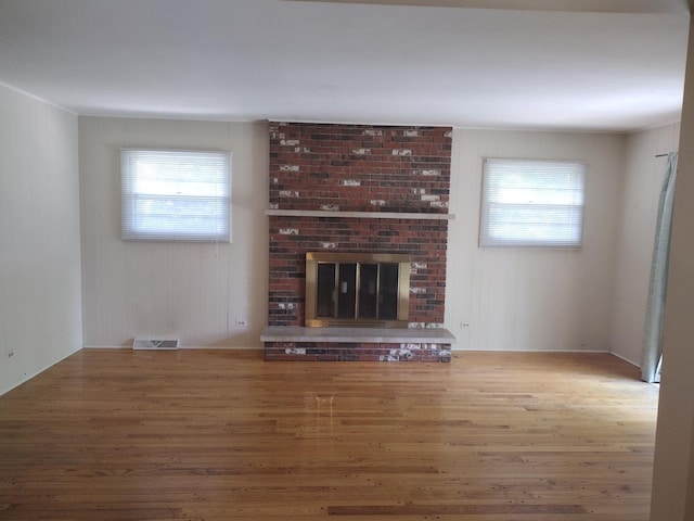 1544 Towhee Ln, Naperville, IL 60565 - unfurnished living room featuring healthy amount of natural light, wood finished floors, and a brick fireplace