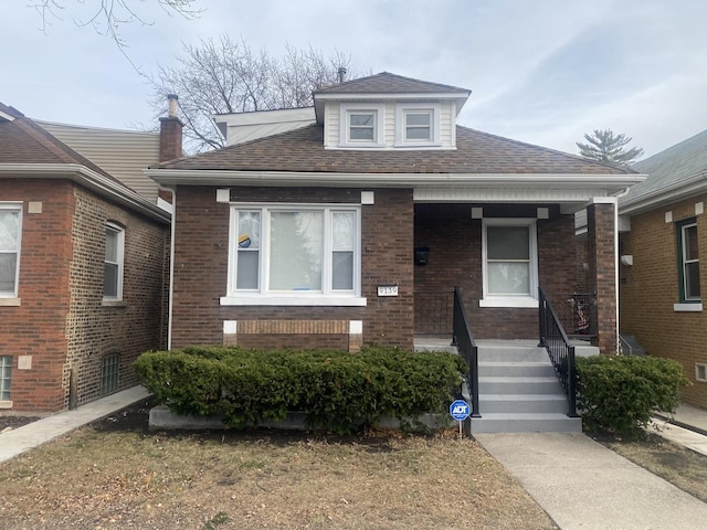 9139 S Colfax Ave, Chicago, IL 60617 - bungalow-style house with a porch, a shingled roof, and brick siding
