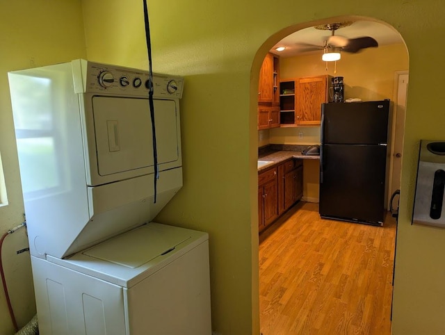 707 E Van Allen St, Tuscola, IL 61953 - washroom featuring stacked washing machine and dryer, arched walkways, and light wood-type flooring