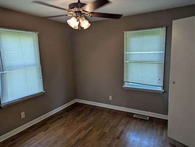 707 E Van Allen St, Tuscola, IL 61953 - empty room featuring dark wood-type flooring, a ceiling fan, and healthy amount of natural light