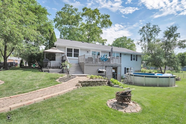 235 Fox Trail Ct, Bourbonnais, IL 60914 - rear view of property with stairway, an outdoor fire pit, a wooden deck, an outdoor pool, and a lawn