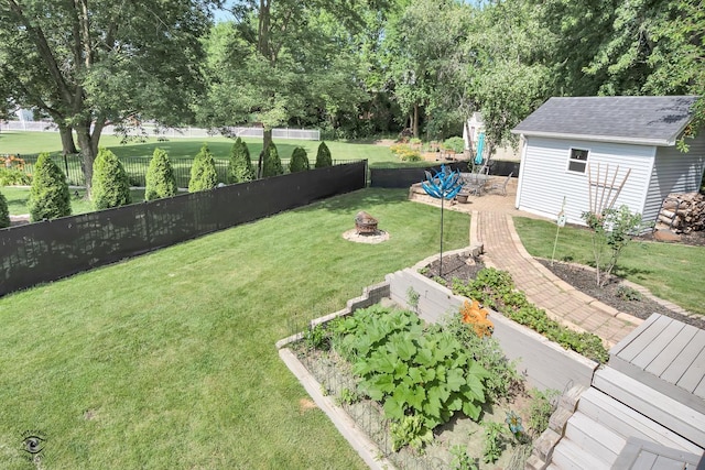 235 Fox Trail Ct, Bourbonnais, IL 60914 - fenced yard featuring a fire pit, an outbuilding, and view of wooded area