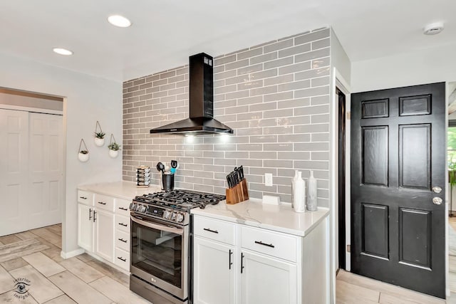 235 Fox Trail Ct, Bourbonnais, IL 60914 - kitchen with gas stove, wall chimney exhaust hood, tasteful backsplash, white cabinetry, and recessed lighting