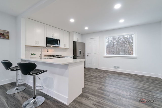 38236 N Lee Ave, Spring Grove, IL 60081 - kitchen with stainless steel appliances, white cabinets, light countertops, a peninsula, and a breakfast bar area