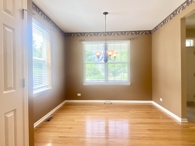 826 Bohannon Cir, Oswego, IL 60543 - unfurnished dining area featuring light wood-type flooring and a chandelier