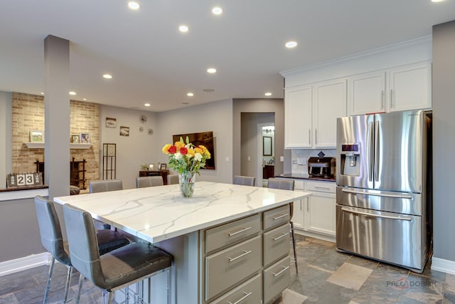 202 Dallas Dr, Bartlett, IL 60103 - kitchen with stainless steel refrigerator with ice dispenser, recessed lighting, a kitchen island, white cabinets, and a breakfast bar area