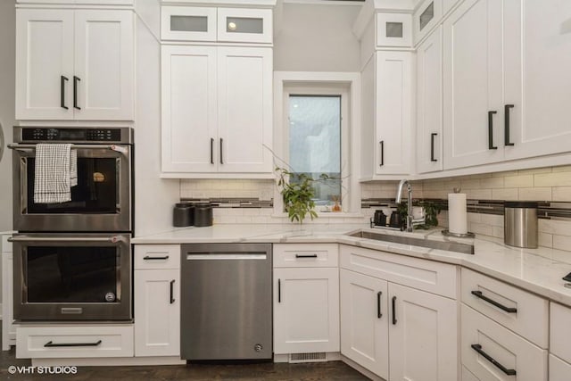 4730 S Champlain Ave Unit 3, Chicago, IL 60615 - kitchen with stainless steel appliances, white cabinetry, backsplash, and light stone countertops