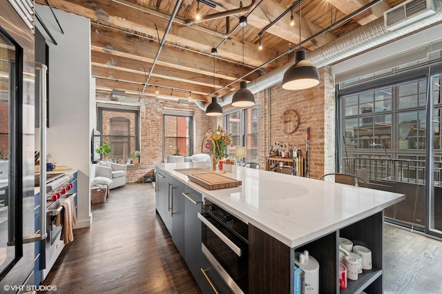 106 N Aberdeen St Unit 3A, Chicago, IL 60607 - kitchen featuring brick wall, stainless steel appliances, open shelves, a center island, and dark wood-style floors