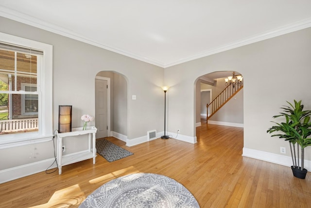 6912 N Osceola Ave, Chicago, IL 60631 - unfurnished room featuring arched walkways, light wood-style floors, ornamental molding, and a chandelier