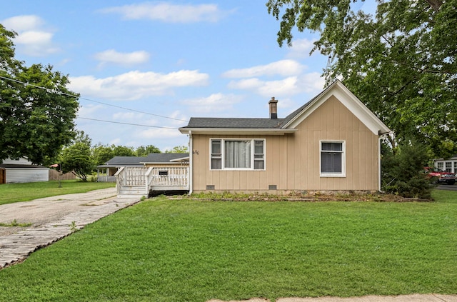 906 N State St, Marengo, IL 60152 - view of front facade with a chimney, a front yard, crawl space, and a wooden deck