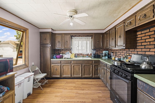 906 N State St, Marengo, IL 60152 - kitchen with gas stove, ceiling fan, light countertops, light wood finished floors, and dark brown cabinetry