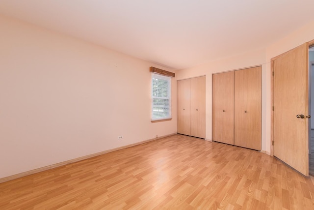 910 Persimmon Ln Unit B, Mount Prospect, IL 60056 - unfurnished bedroom featuring multiple closets and light wood finished floors