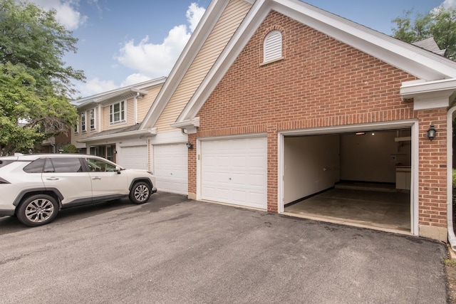 910 Persimmon Ln Unit B, Mount Prospect, IL 60056 - view of side of home with brick siding, asphalt driveway, and a garage