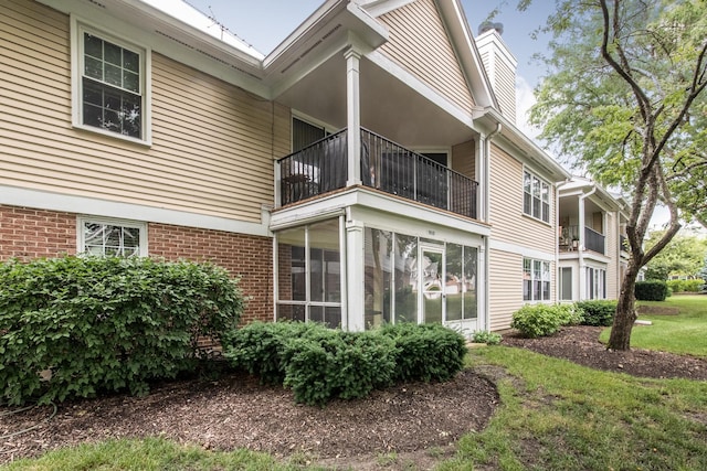 910 Persimmon Ln Unit B, Mount Prospect, IL 60056 - back of property with a balcony, brick siding, and a chimney