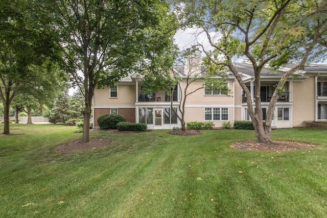 910 Persimmon Ln Unit B, Mount Prospect, IL 60056 - back of house featuring a chimney, a lawn, and a balcony