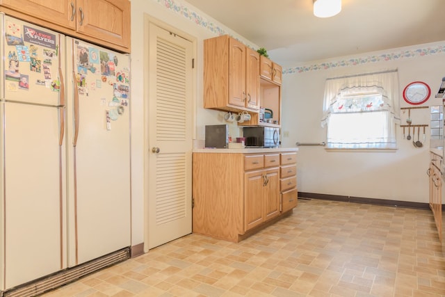 129 N Chase Ave, Bartlett, IL 60103 - kitchen featuring freestanding refrigerator, light countertops, stainless steel microwave, and brick patterned flooring