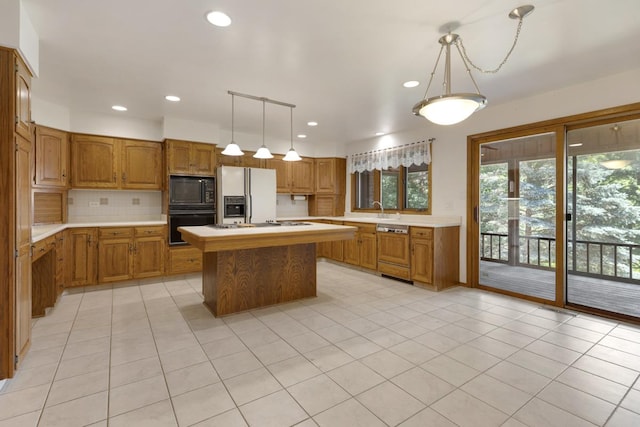 39081 N Sheridan Rd, Antioch, IL 60002 - kitchen featuring black appliances, light countertops, tasteful backsplash, brown cabinetry, and recessed lighting