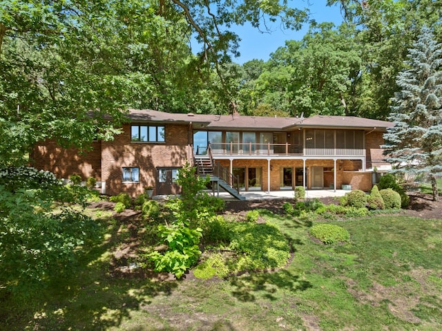 39081 N Sheridan Rd, Antioch, IL 60002 - rear view of house featuring a sunroom, brick siding, stairs, and a patio area