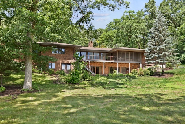 39081 N Sheridan Rd, Antioch, IL 60002 - rear view of house featuring brick siding, a sunroom, a chimney, and a lawn