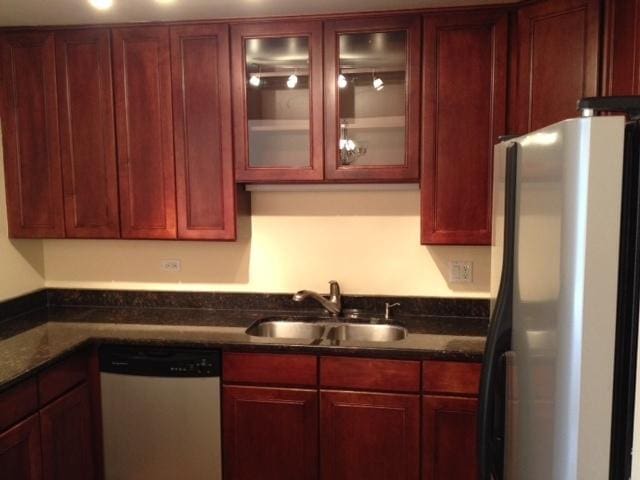 442 E Osage Ln Unit 3A, Palatine, IL 60067 - kitchen featuring freestanding refrigerator, stainless steel dishwasher, reddish brown cabinets, glass insert cabinets, and dark stone countertops