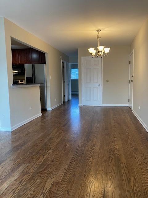442 E Osage Ln Unit 3A, Palatine, IL 60067 - unfurnished living room featuring a chandelier and dark wood finished floors