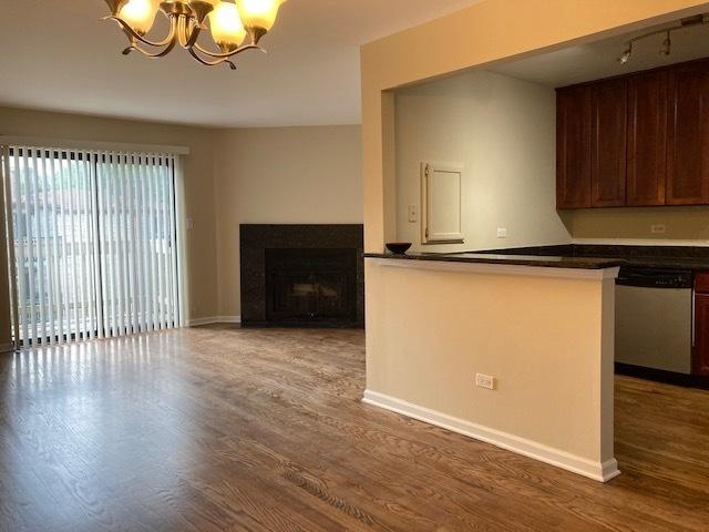 442 E Osage Ln Unit 3A, Palatine, IL 60067 - kitchen with stainless steel dishwasher, dark countertops, a chandelier, and wood finished floors