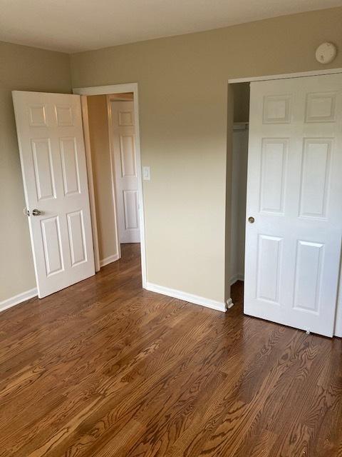 442 E Osage Ln Unit 3A, Palatine, IL 60067 - unfurnished bedroom with dark wood-style floors and a closet