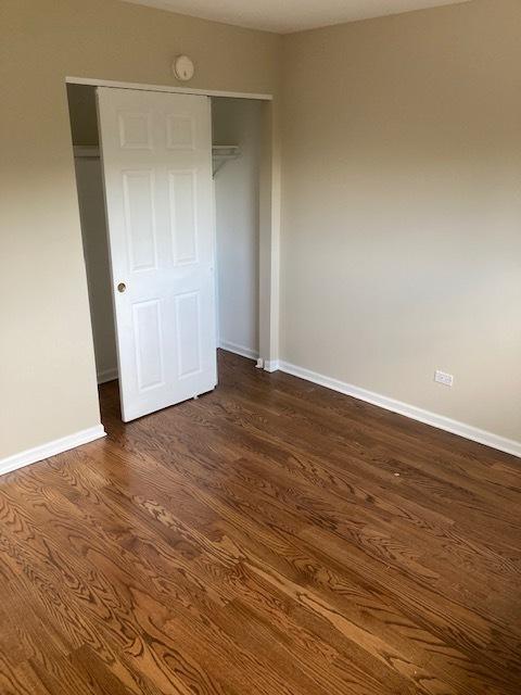 442 E Osage Ln Unit 3A, Palatine, IL 60067 - unfurnished bedroom featuring dark wood finished floors and a closet